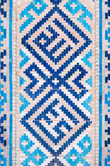 ancient ceramic tile with a traditional oriental pattern Uzbek ornament decorates the wall of the...