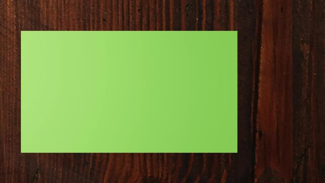 3d Paper (green screen) slideshow on a wooden desk. Can be used for displaying photos, articles. 3d animation. 4K