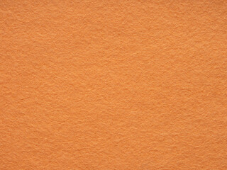 Sun-kissed amber warmth radiates from the close-up texture of a plush orange felt background