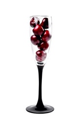 Ripe natural cherries, sweet cherries in a tall glass on a white background, close-up