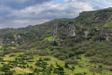 Fototapeta premium Steep mountain slope with rocky ledges. Mountain range on the border of Ukraine and Romania on a cloudy, summer day