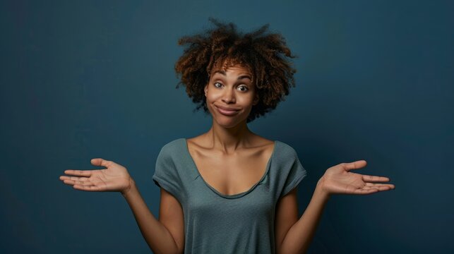 Person Expressing Uncertainty and Doubt by Shrugging on Blue Backdrop	