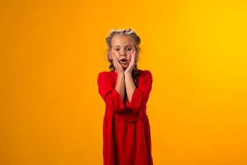 Surprised kid girl over yellow background. Astonishment emotion concept