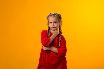 Thoughtful child girl touching chin with finger thinking or considering