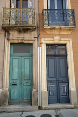 Fachada con puertas antiguas en azul y verde con sus balcones.