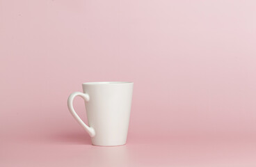 white cup for tea or coffee on a pink background