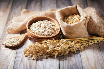 grains of oats, oatmeal and oats spikelets on wooden background