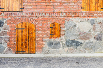 Brick wall with wooden shutters on windows adds rustic charm to the building