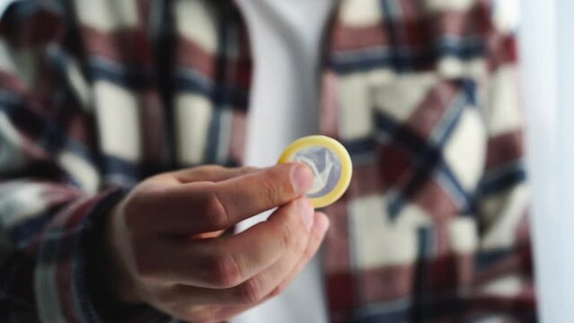 condom in the hands of a man.
Sexual health.
Methods of contraception.