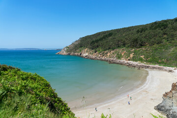 L'été, une plage de la presqu'île de Crozon encadrée par des falaises, surplombant la mer d'Iroise.