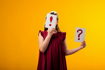 Kid girl holding exclamation point card in front of her face. Children, idea and knowledge concept