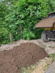 Obraz premium Dumping soil out of a dumper at a construction side. Vertical shoot.