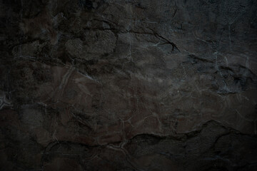 Empty cracked brown black stone wall on cave for abstract background and texture. beautiful patterns, space for work, banner, seamless wallpaper close up.