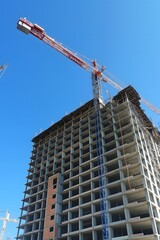 large construction of a high-rise building with a crane and equipment in Russia