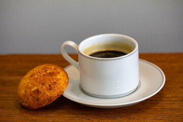 Afternoon coffee served in a white cup with cornbread or cheese bread