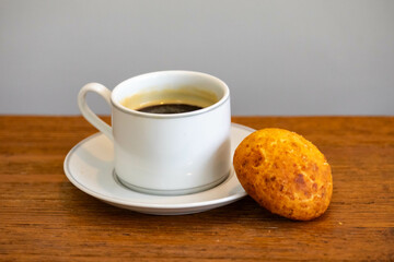 Afternoon coffee served in a white cup with cornbread or cheese bread