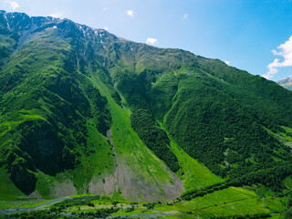 green forest on rocky mountain slopes - aerial drone shot