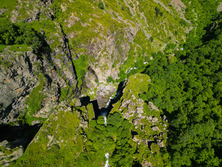  Gveleti waterfall falls from steep cliffs in a gorge in Georgia - drone photo.
