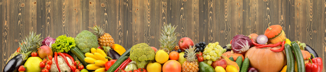 Panoramic photo healthy vegetables and fruits on background wooden wall.