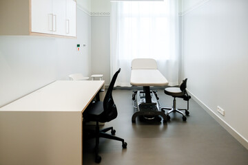 A doctor's office with a couch and a chair to examine a patient's health