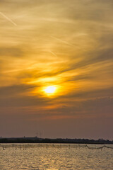 Magic sunset over the water of the lagoon: orange sun and sky