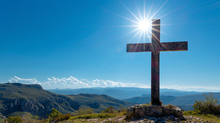 A Christian cross on a high plateau during a clear day, with the unobstructed sun illuminating the cross and the bright blue sky providing a vivid canvas behind it.