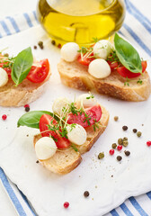 Round mozzarella, cherry tomatoes and microgreens on a piece of white bread, a healthy sandwich