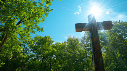 A Christian cross in a quiet forest clearing, with a sudden break in the canopy allowing the sunlight to stream down directly on the cross, against a brilliantly clear blue sky.