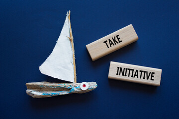 Take initiative symbol. Wooden blocks with words Take initiative. Beautiful deep blue background...