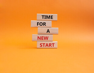 Time for a new start symbol. Wooden blocks with words Time for a new start. Beautiful orange...