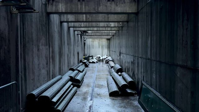 Concrete long rectangular tunnel with storage of building materials, bunker perspective view