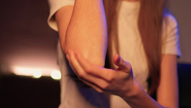 Close up of young woman applying moisturizing body lotion on smooth skin of arm. Female hand massaging shoulder and elbow with natural nourishing soft cream. Skincare, dermatology concept