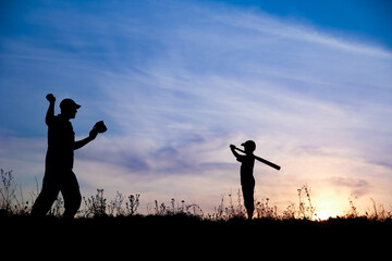 A Happy child with parent playing baseball concept in park in nature