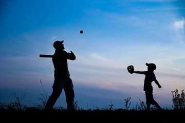 A Happy child with parent playing baseball concept in park in nature