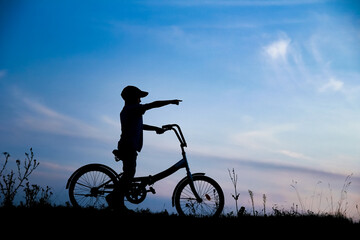 A Happy child and bike concept in park outdoors silhouette