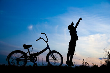 A Happy child and bike concept in park outdoors silhouette