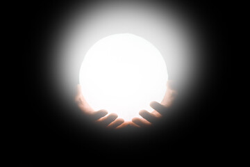 A The moon in the hands of a man on a black background