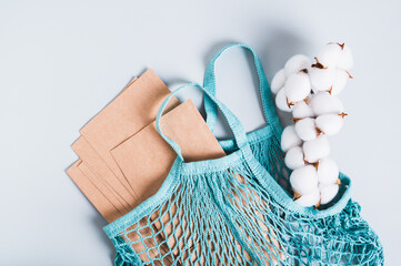 Refusal of plastic bags, a string bag filled with paper bags and a cotton branch