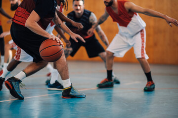 Unrecognizable diverse team playing basketball at a gymnasium or a sports hall