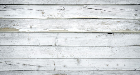White painted wood boards or siding or wall with cracks and distressed finish