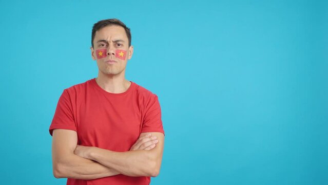 Dignified and serious man with vietnamese flag painted on face