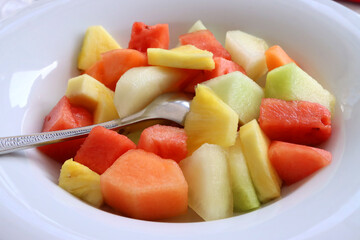 Plate of sliced ​​fresh summer fruits. Melon, pineapple, watermelon