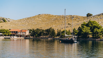 Old ship with sails and lifeboat floating off Dugi Otok island coast in Adriatic Sea, Croatia