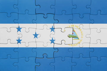 puzzle with the colourful national flag of nicaragua and flag of honduras .
