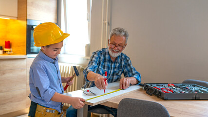 Learning craft with grandpa. Grandpa's little helper. Grandfather teaching his grandson. Boy and...