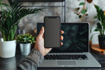 Person using laptop and holding phone