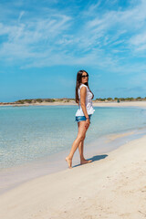 Happy woman walking on a tropical beach. Summer vacation concept.