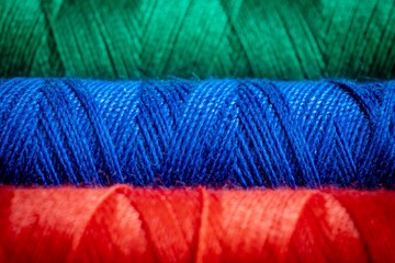 close up colored sewing thread, red, blue green, background