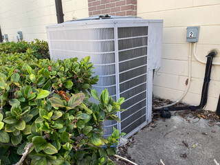 Fototapeta premium Air conditioner unit exterior side view wall outlet and bush