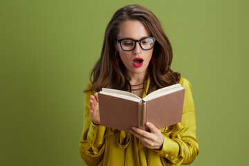 surprised healthy woman in green blouse and glasses on green